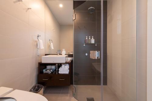 uma casa de banho com um chuveiro e um lavatório. em The Freshwater em Niseko