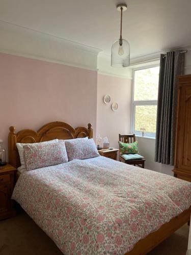 ein Schlafzimmer mit einem großen Bett und einem Fenster in der Unterkunft Seaitall in Torquay