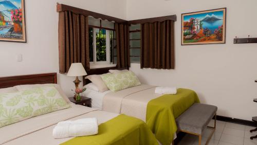 een hotelkamer met 2 bedden en een raam bij AMINA Inn in Flores