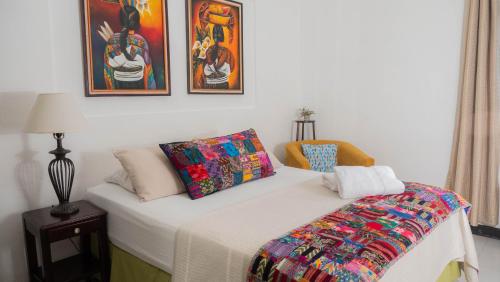 Un dormitorio con una cama con una manta de colores. en AMINA Inn en Flores
