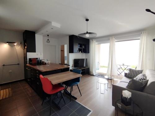 une cuisine et un salon avec une table et un canapé dans l'établissement Le Cocon de la baie de Sion, à Saint-Hilaire-de-Riez