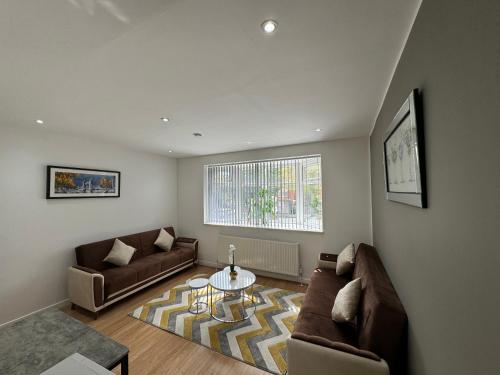ein Wohnzimmer mit einem Sofa und einem Tisch in der Unterkunft MK Apartments South MCR, Chorlton in Manchester