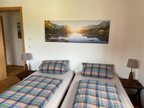 a bedroom with two beds and a painting on the wall at Meridiana 2 in Tuntenhausen