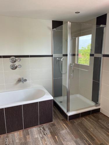 a bathroom with a shower and a bath tub at Meridiana 2 in Tuntenhausen