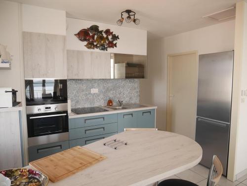 - une cuisine avec une table en bois dans l'établissement Le bel'vue de St Hilaire, à Saint-Hilaire-de-Riez