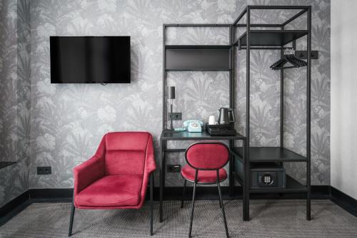 a bedroom with a desk and a red chair at Krisotel in Amsterdam