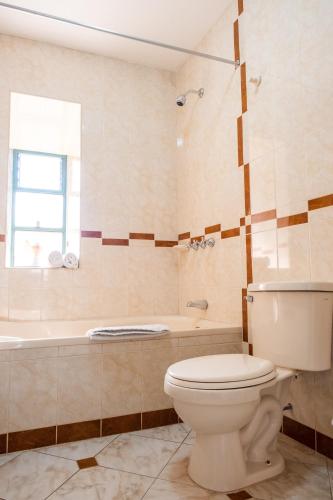 a bathroom with a toilet and a bath tub at Hospedaje La Florida in Urubamba
