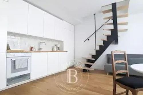 een keuken met witte kasten en een trap bij Charmant Duplex neuf calme au cœur de la station in Bénodet