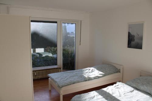 1 Schlafzimmer mit 2 Betten und einem großen Fenster in der Unterkunft Zweites Zuhause in Recklinghausen