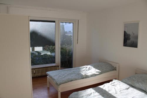 a bedroom with two beds and a large window at Zweites Zuhause in Recklinghausen