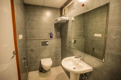 a bathroom with a sink and a toilet and a mirror at Aarna studio in Jaipur