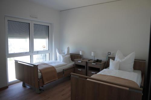 a bedroom with two beds and a window at ISA Rheinquartier - Moderne und barrierefreie Ferienapartments in Lahnstein
