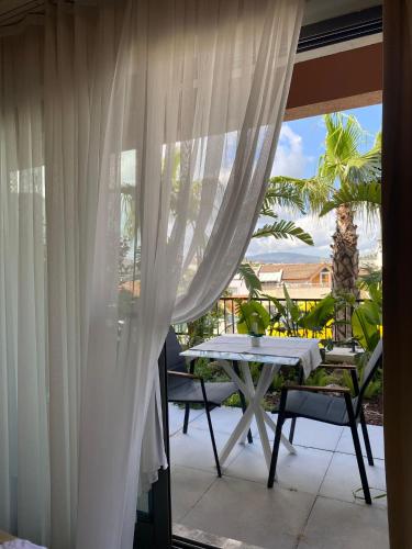a balcony with white curtains and a table and chairs at KUCA URLA in Urla