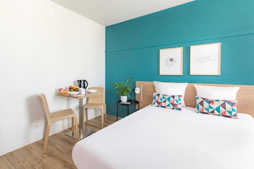 a bedroom with a bed and a small table at Appart'City Classic Paris La Villette in Paris