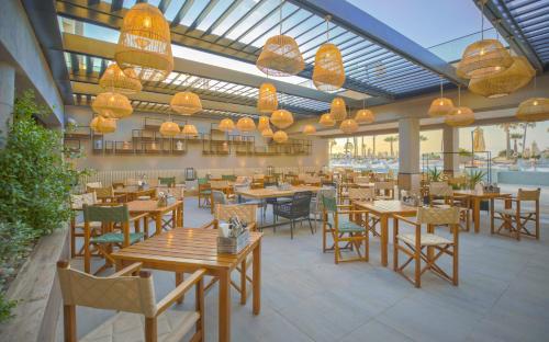 a restaurant with wooden tables and chairs and lights at Hilton Skanes Monastir Beach Resort in Monastir