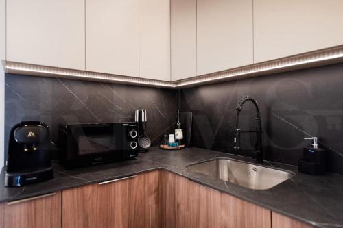 een aanrecht met een spoelbak en een magnetron bij Apartment with terrace steps from beach REMS in Fuengirola