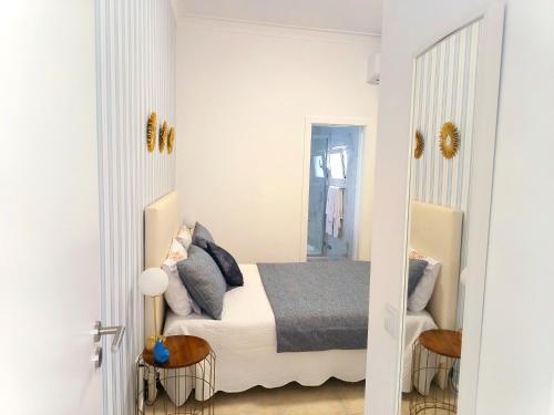 a bedroom with a bed and two end tables at MAR ROSA, estacionamento gratuito in Nazaré