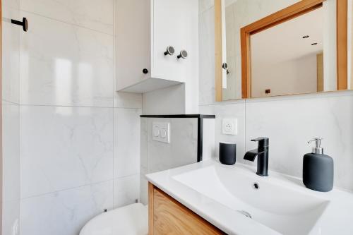une salle de bain avec un lavabo, des toilettes et un miroir dans l'établissement Appartement 2 personnes - Tour Eiffel, à Paris
