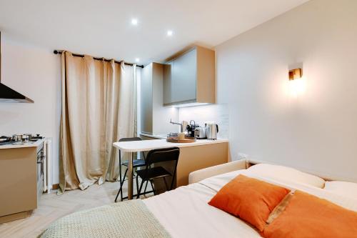une chambre avec un lit et un bureau et une cuisine dans l'établissement Appartement 2 personnes - Tour Eiffel, à Paris