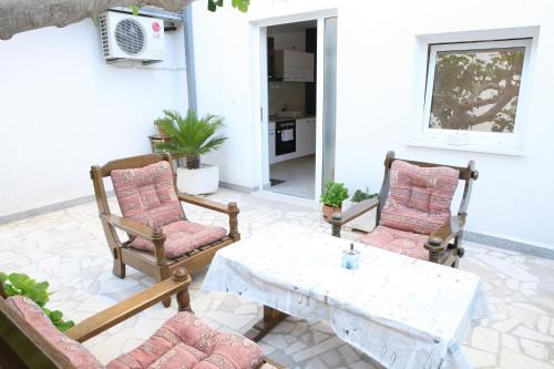 un patio con 2 sillas, una mesa y una mesa en Apartments Old Town, en Trogir