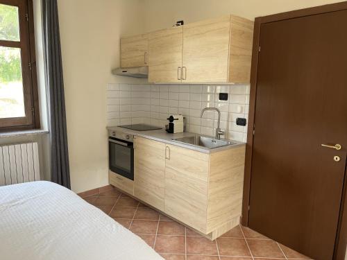 a small kitchen with wooden cabinets and a sink at Case Vista Alta Langa, Studio Belbo in Cravanzana
