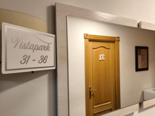 a mirror in a bathroom with a wooden door at Hostería VISTAPARK in El Astillero