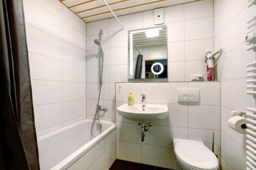 uma casa de banho branca com um lavatório e um WC em Ferienwohnung Bergrose em Obermaiselstein
