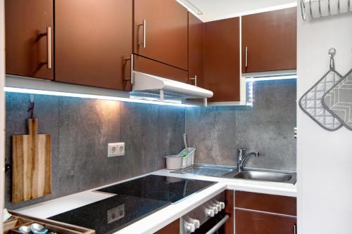 a kitchen with brown cabinets and a sink at Ferienwohnung Bergrose in Obermaiselstein