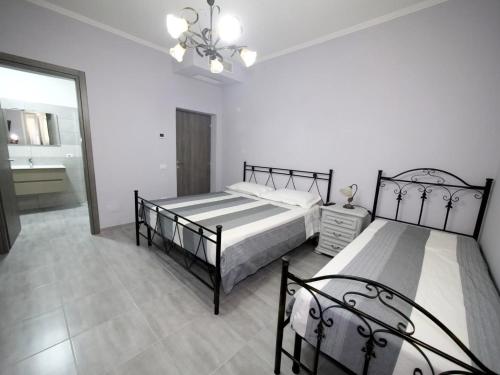 a bedroom with two beds and a chandelier at Beb Da Tina in Roccasecca