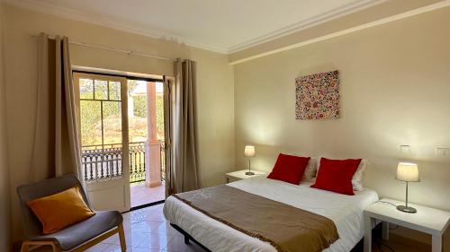 Un dormitorio con una cama con almohadas rojas y una ventana en Bicos J by Check-in Portugal, en Albufeira