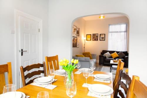 a dining room with a table with yellow flowers on it at 4 Bedrooms Spacious House With 2 Bathrooms Free Parking - sleeps up to 10 guests in Liverpool