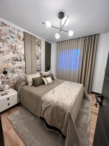 a bedroom with a large bed with a floral wall at Atico LUXURY Magic World in Oropesa del Mar