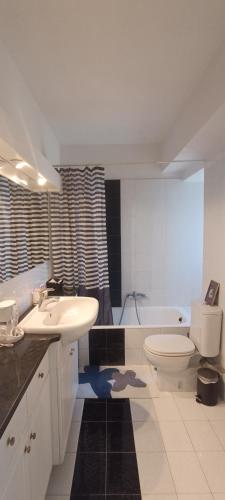 a bathroom with a sink and a toilet and a tub at Cozy Room with Sea View in Athens