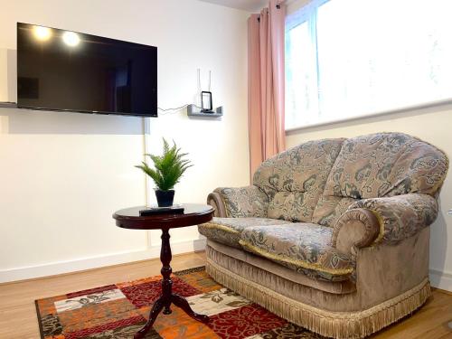 een woonkamer met een bank, een tafel en een televisie bij Penn Gardens Flat 1 - 2 - 3 & 4 Apartments in Havering atte Bower