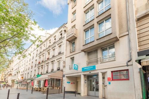 an apartment building on a street with a street sign at Appart'City Classic Paris La Villette in Paris