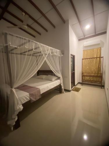 a bedroom with a bed with a mosquito net at Bloom Star7 in Unawatuna