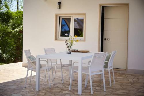 a white dining room table with white chairs at Villa D'Aprile Exclusive Luxury Villa with pool, Jacuzzi, SPA in Castellana Grotte