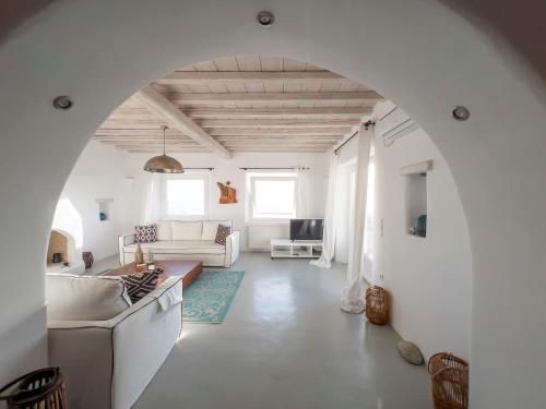 una sala de estar con muebles blancos y un arco en Villa Prive 77 Mykonos, en Mykonos ciudad