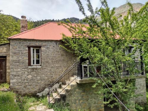 uma casa de pedra com uma escada que leva até ela em Rustic and Remote Stone Cottage em Arta