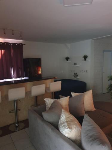 - un salon avec un canapé et des oreillers dans l'établissement L'atypique cosy, à Santeny