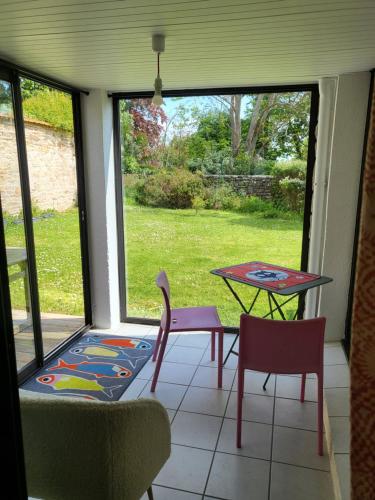 une véranda avec une table et des chaises dans l'établissement LE BLEU HORIZON, à Fouesnant