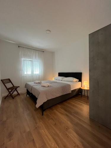 1 dormitorio con 1 cama y 1 silla en Apartmani Nina Medjugorje, en Međugorje