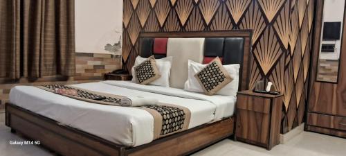 een slaapkamer met een groot bed met een houten hoofdeinde bij Angel Pink Residency B58 in Ghaziabad