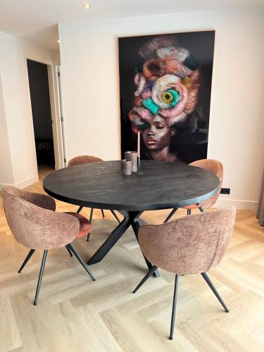 a black table with chairs in a room with a painting at Boulevard 3F in Arnhem