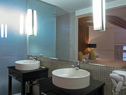 uma casa de banho com 2 lavatórios e um espelho grande em HTL 9 de Julio BsAs em Buenos Aires