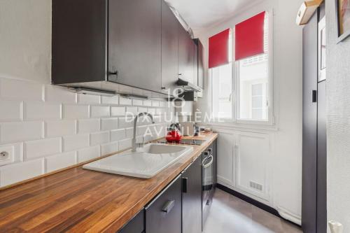 une cuisine avec un évier et un plan de travail dans l'établissement Modernité et confort à Montmartre, à Paris
