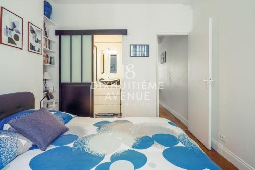 une chambre avec un lit avec un couvre-lit bleu et blanc dans l'établissement Modernité et confort à Montmartre, à Paris