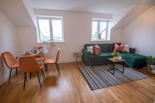 a living room with a green couch and a table at Cozy Living in Abbey Woods in Abbey Wood