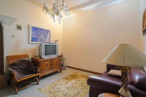 - un salon avec un canapé et une télévision dans l'établissement Mitra Dago Antapani Syariah, à Bandung