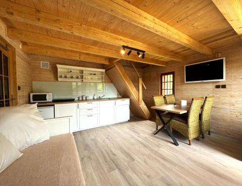 ein Schlafzimmer mit einem Bett und einem Tisch sowie eine Küche in der Unterkunft Chata RESTART in Jevíčko